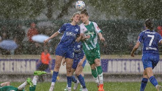 Werder-Spielerin Lisa-Marie Weiss bei strömendem Regen im Kopfballduell mit Meppens Michelle Ulbrich.