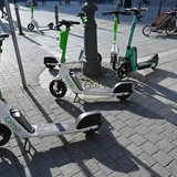E-Scooter von Lime stehen auf einem Platz.