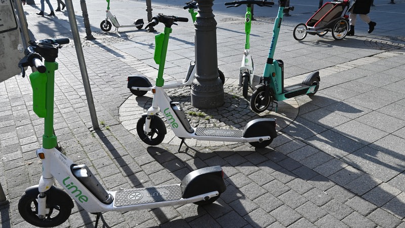 E-Scooter von Lime stehen auf einem Platz.