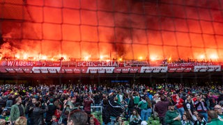 Blick auf den Bayern-Gästeblock im Weser-Stadion, in den Fans etliche Pyro-Fackeln gezündet haben.