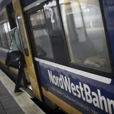 Eine Bahnreisende steigt in Verden in eine Nordwestbahn nach Bremen ein