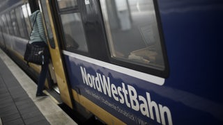 Eine Bahnreisende steigt in Verden in eine Nordwestbahn nach Bremen ein