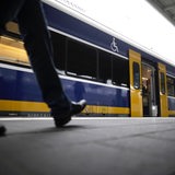 Eine Person am Bahnsteig vor einer Nordwestbahn.