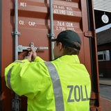 Ein Mitarbeiter des Zolls öffnet einen Container.