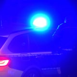 Nachtaufnahme eines Polizeifahrzeugs mit Blaulicht (Symbolbild)