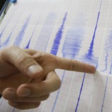 Ein Mann zeigt auf einen Seismographen.