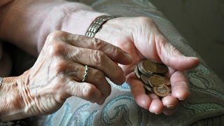 Eine Seniorin zählt Euro-Münzen in ihrer Hand (Symbolbild)