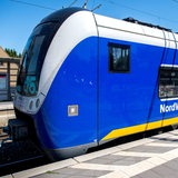 Ein Zug der Nordwestbahn steht an einem Bahnsteig.