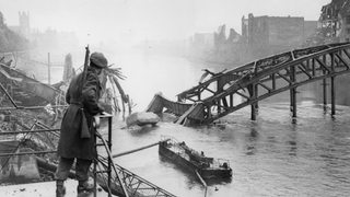 Britischer Soldat vor zerstörter Brücke über die Weser
