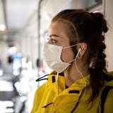 Eine Frau mit einer Schutzmaske steht in einer Bremer Straßenbahn.