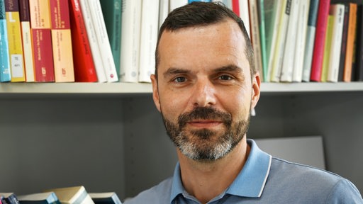 Andreas Klee, Professor, Politikwissenschaftler und Direktor des Zentrum für Arbeit und Politik an der Universität Bremen, steht in seinem Büro. 