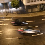 Zwei Autos rasen über eine Straße. Die Autos sind durch Bewegungsunschärfe verwischt dargestellt. Es handelt sich um ein Symboldbild.