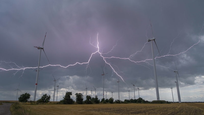 Blitze eines Gewitters leuchten über Windenergieanlagen vom Windpark "Odervorland" im Landkreis Oder-Spree.