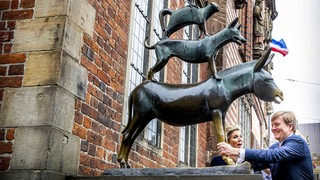 Willem-Alexander umfasst die Beine des Esels der Bremer Stadtmusikanten