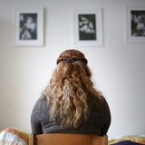 Eine junge Frau sitzt im Schlafzimmer eines Frauenhauses.