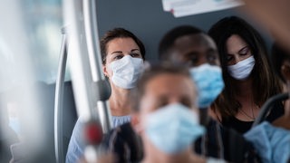 Passagiere mit Masken in einem Bus