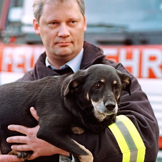 Feuerwehrmann mit Hund auf dem Arm, 2000 (Archivbild)