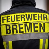 Feuerwehrmann mit dem Schriftzug "Feuerwehr Bremen" auf dem Rücken.