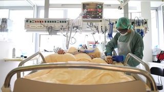 Ein Corona-Patient wird auf einer Intensivstation in einem Krankenhaus versorgt.