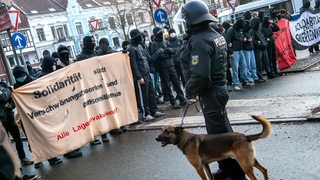 Gegendemonstranten zur "Querdenker"-Demo in Bremen stehen Polizisten gegenüber.