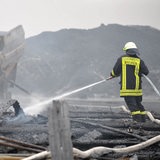 Ein Feuerwehrmann löscht den Brand einer Lagerhalle in Bremen.