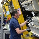 Ein Mann steht an einer großen Maschine im Mercedes-Werk in Bremen