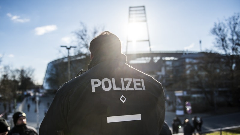 Ein Polizist im Gegenlicht vor dem Weser-Stadion.