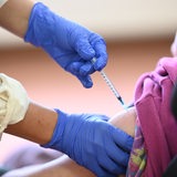 Frau wird in den Arm geimpft.