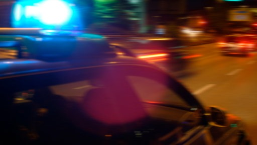 Polizeifahrzeug mit Blaulicht verfolgt einen Pkw (Symbolbild)
