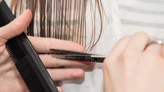 Einer Frau werden die Haare geschnitten (Symbolbild)