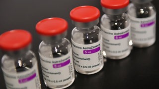 Astra Zeneca COVID-19-Impfdosen stehen in einer Reihe.