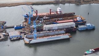 Eine Luftaufnahme zeigt das Marine-Segelschulschiff "Gorch Fock", welches im vorderen Baudock der Bredo-Werft repariert wird und mit Planen abgedeckt ist.