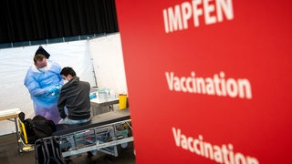 Ein Mann wird im Bremer Impfzentrum geimpft