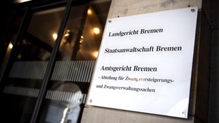 Ein Schild an einer Hauswand, auf dem "Landgericht Bremen" steht