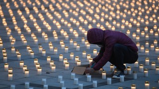 Aufgestellte Kerzen erinnern an die vielen Toten der Corona-Pandemie (Archivbild)