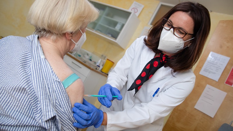 Eine Hausärztin impft eine ältere Patientin gegen das Coronavirus mit dem Impfstoff von Biontech