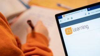 Die Website der Lernplattform "itslearning" ist am 23.03.2020 in einer Wohnung in Berlin auf einem Notebook zu sehen, waehrend im Hintergrund ein Kind am Schreibtisch sitzt (gestellte Szene).