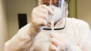 Ein Labormitarbeiter führt einen Coronatest durch.