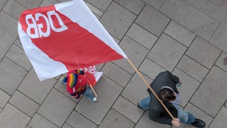 Ein Mann und ein Kind demonstrieren mit einer Fahne des deutschen Gewerkschafts-Bunds.