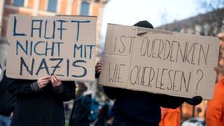 Gegendemonstranten zur «Querdenker»-Demo halten Plakate mit den Aufschriften "Lauft nicht mit Nazis" und "Ist Querdenken wie Querlesen?"