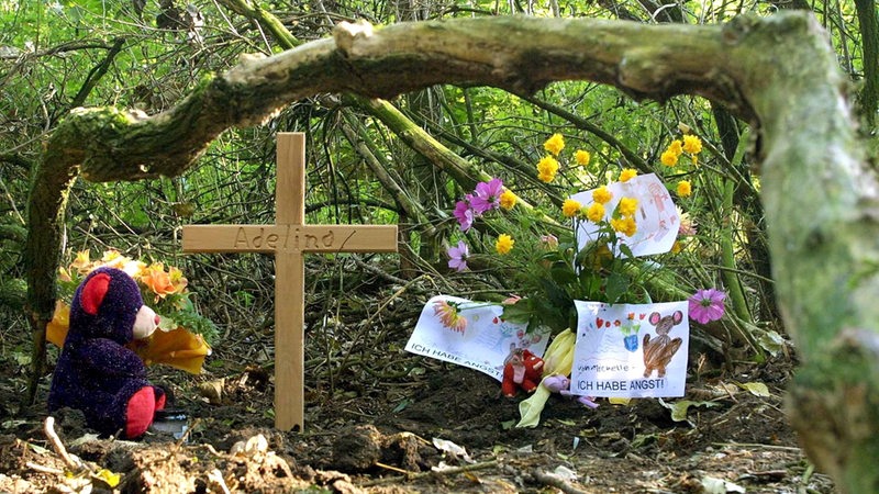 Der Fundort der Leiche des ermordeten Mädchens Adelina in einem Wald bei Leeste ist am 12.10.2001 mit einem Teddybär, Blumen und einem Holzkreuz geschmückt.