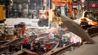 In der Bremer Innenstadt arbeiten Bauarbeiter im abgesperrten Bereichen an den Straßenbahnschienen