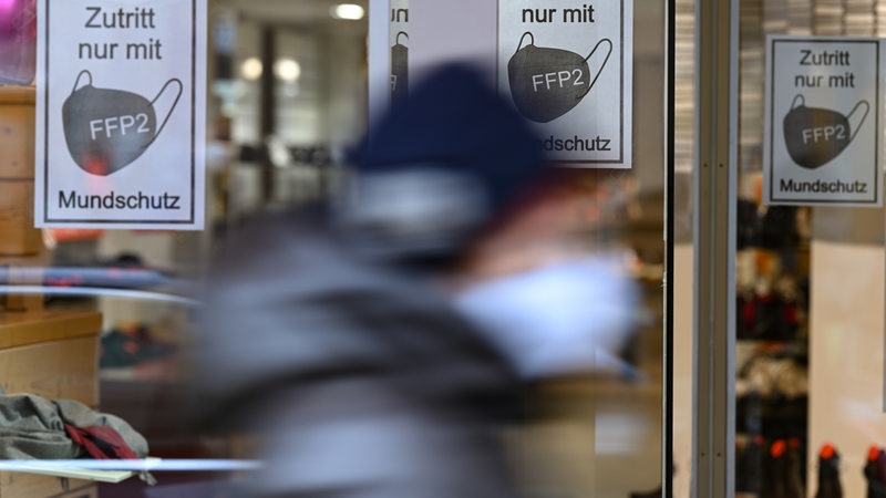 n den Schaufenstern eines Schuhgeschäfts in der Frankfurter Innenstadt sind Hinweise mit der Aufschrift "Zutritt nur mit FFP 2 Mundschutz" angebracht.