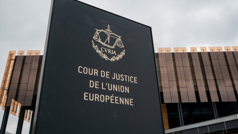 Das Foto zeigt ein Schild mit der Aufschrift "Cour de Justice de l'Union Europeene" vor einem Gebäude des Europäischen Gerichtshofs (EuGH) in Luxemburg.
