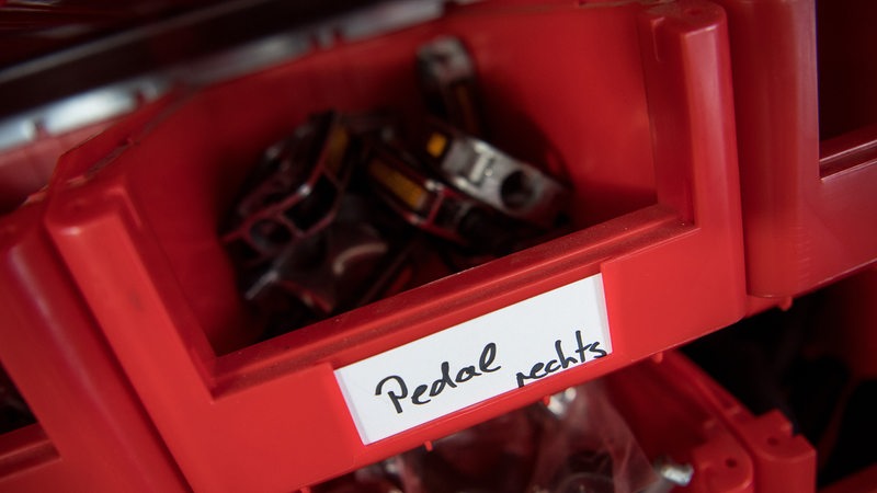 Rechte Pedale und weitere Teile liegen in einem Regal in einem Fahrradhändler (Archivbild)