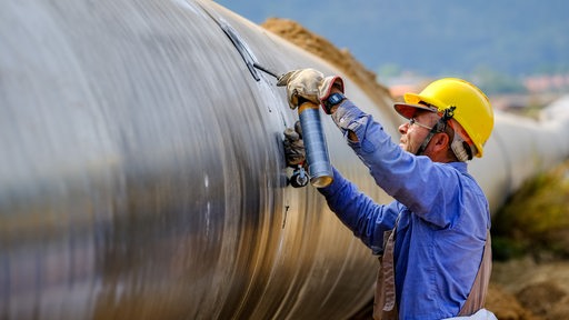 Ein Bauarbeiter arbeitet an der Absenkung einer Gaspipeline
