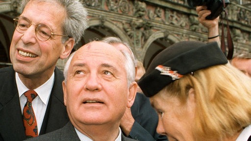 Der ehemalige russische Staatspräsident Michail Gorbatschow wird bei einem Besuch in Bremen 1997 von einer Fremdenführerin unter Begleitung von Henning Scherf, durch die Innenstadt geführt. (Archivbild)