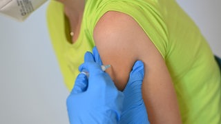 Impfstoff wird mit Impfspritze wird bei einer Frau in den Oberarm gespritzt. (Archivbild)
