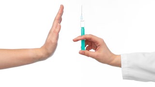 Eine ausgestreckte Hand mit einer Spritze gegenüber einer Hand in abwehrender Haltung.