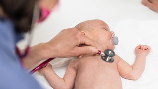 Ein Baby wird von einer Kinderärztin untersucht (Symbolbild)